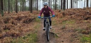 Teenagers (11-14 years) enjoying a guided mountain bike ride through the Surrey Hills woodland