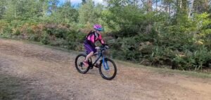 Young girl learning off-road cycling skills on a taster ride in the Surrey Hills with Marmalade MTB