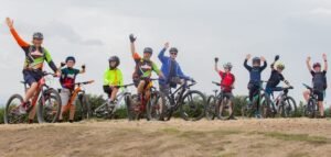 Happy child on a mountain bike, smiling as they cycle through nature, highlighting the fun and outdoor adventure of the sport