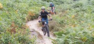 Happy child on a mountain bike, smiling as they cycle through nature, highlighting the fun and outdoor adventure of the sport