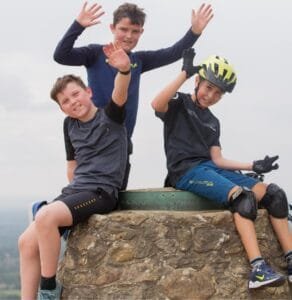 Happy child on a mountain bike, smiling as they cycle through nature, highlighting the fun and outdoor adventure of the sport