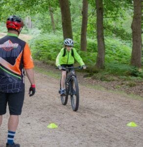 Happy child on a mountain bike, smiling as they cycle through nature, highlighting the fun and outdoor adventure of the sport