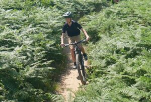 Happy child on a mountain bike, smiling as they cycle through nature, highlighting the fun and outdoor adventure of the sport
