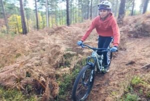 Happy child on a mountain bike, smiling as they cycle through nature, highlighting the fun and outdoor adventure of the sport