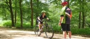 Happy child on a mountain bike, smiling as they cycle through nature, highlighting the fun and outdoor adventure of the sport