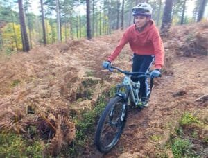 Happy child on a mountain bike, smiling as they cycle through nature, highlighting the fun and outdoor adventure of the sport