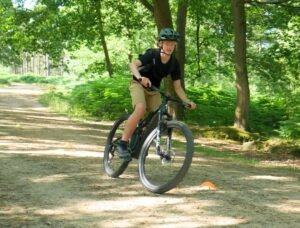 Happy child on a mountain bike, smiling as they cycle through nature, highlighting the fun and outdoor adventure of the sport