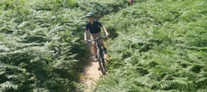 Happy child on a mountain bike, smiling as they cycle through nature, highlighting the fun and outdoor adventure of the sport
