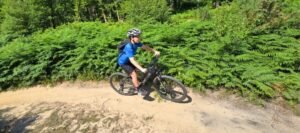 Happy child on a mountain bike, smiling as they cycle through nature, highlighting the fun and outdoor adventure of the sport