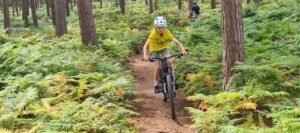 Happy child on a mountain bike, smiling as they cycle through nature, highlighting the fun and outdoor adventure of the sport